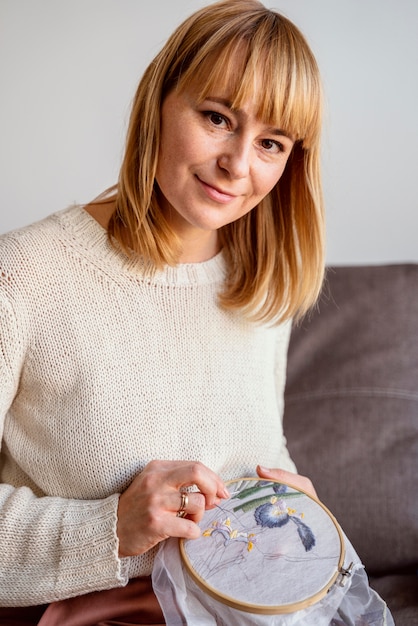 Happy crafter holding embroidered hoop